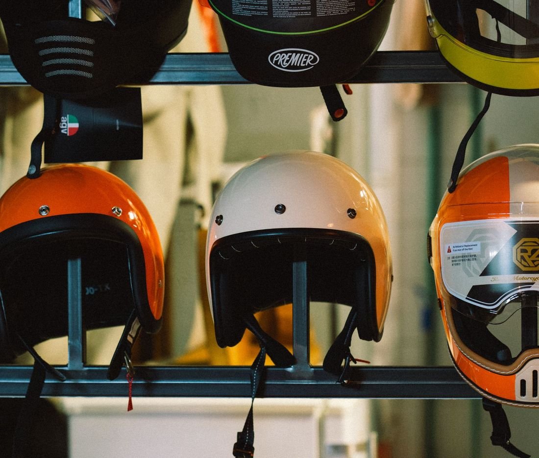 A rack of colourful open-face and full-face helmets ready for the next rental